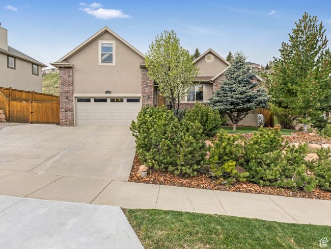 View of front facade featuring stucco siding, a garage, concrete driveway, and fence | Image 4