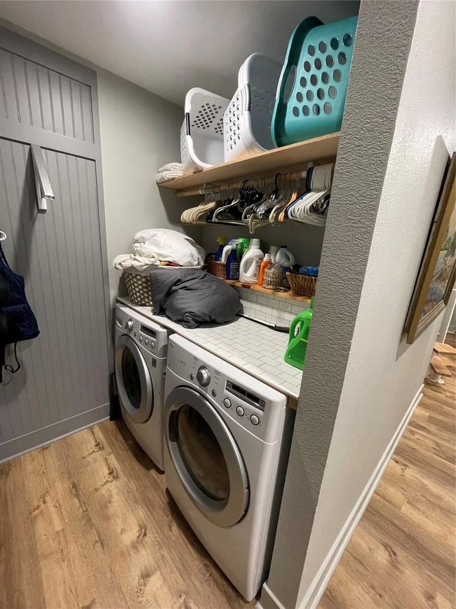 Laundry room with washer and clothes dryer and light wood-type flooring | Image 17