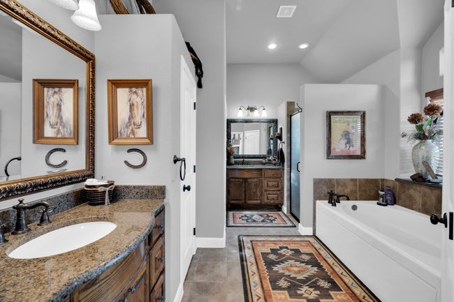 Bathroom with tile patterned floors, vanity, vaulted ceiling, and a tub to relax in | Image 18