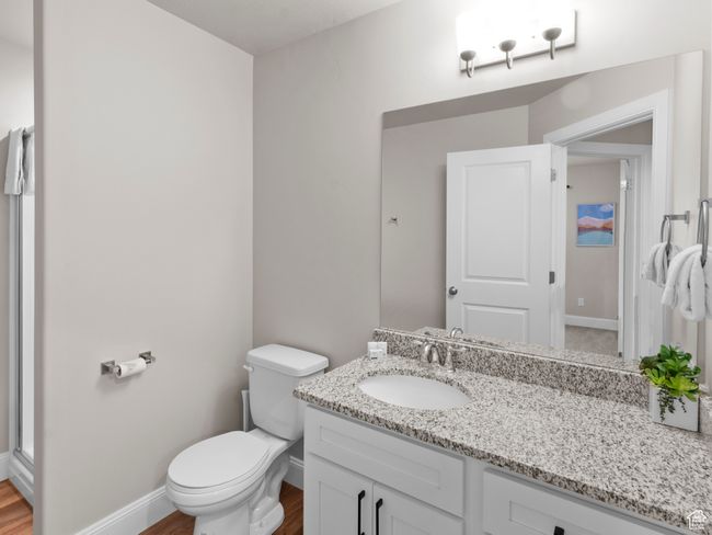 Bathroom featuring baseboards, wood finished floors, toilet, and vanity | Image 22