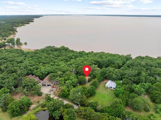 Aerial view of property and surrounding area featuring a large body of water and a heavily wooded area | Image 5