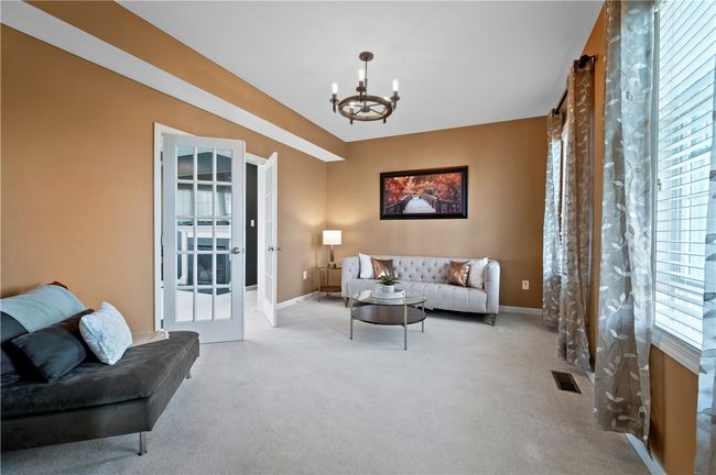 The formal living room opens into the family room. It includes custom lighting and neutral décor. | Image 9
