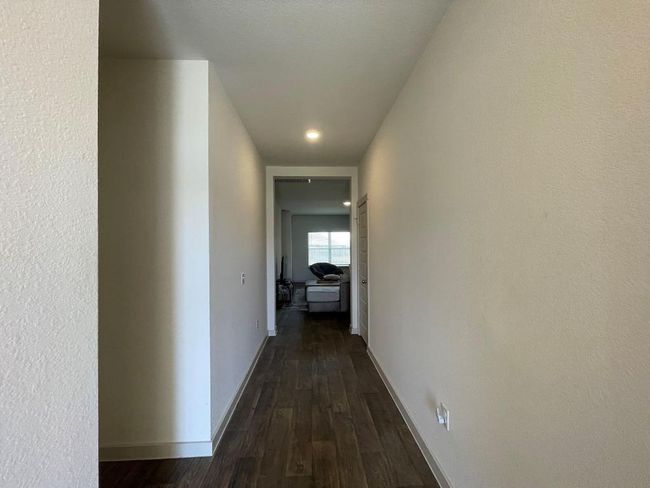 Hall featuring dark wood finished floors and baseboards | Image 4
