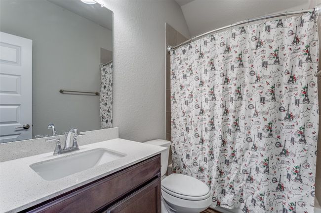 Full bath featuring vanity, curtained shower, and a textured wall | Image 15