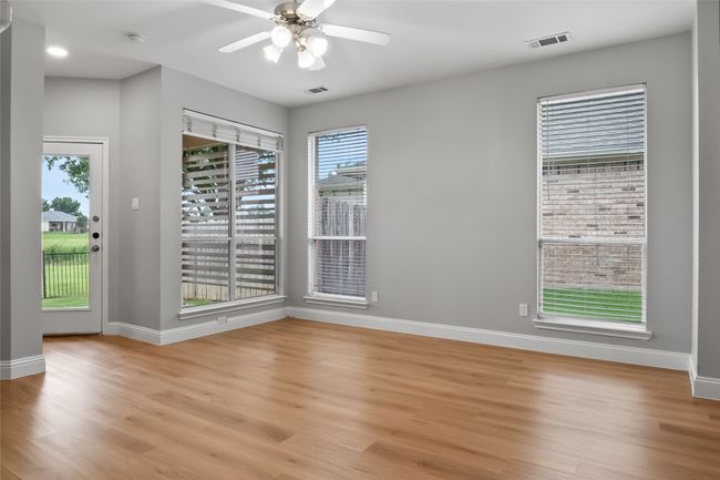 Empty room with light wood-style flooring, baseboards, and a ceiling fan | Image 18