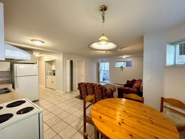 Kitchen featuring white appliances, light tile patterned floors, pendant lighting, and light countertops | Image 5