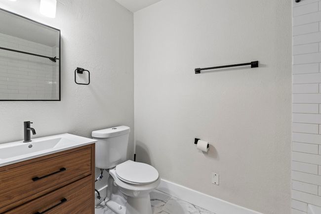 Bathroom featuring toilet, marble finish flooring, vanity, and baseboards | Image 19