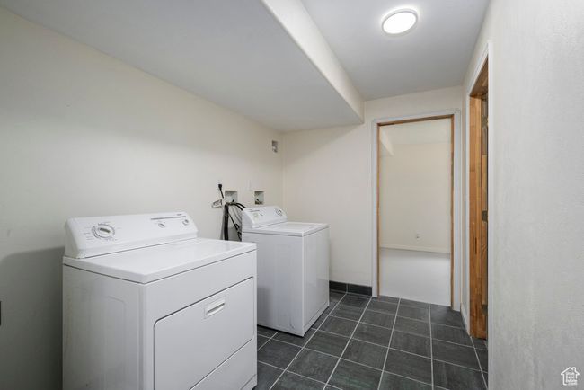 Clothes washing area with laundry area, dark tile patterned floors, and washer and dryer | Image 44