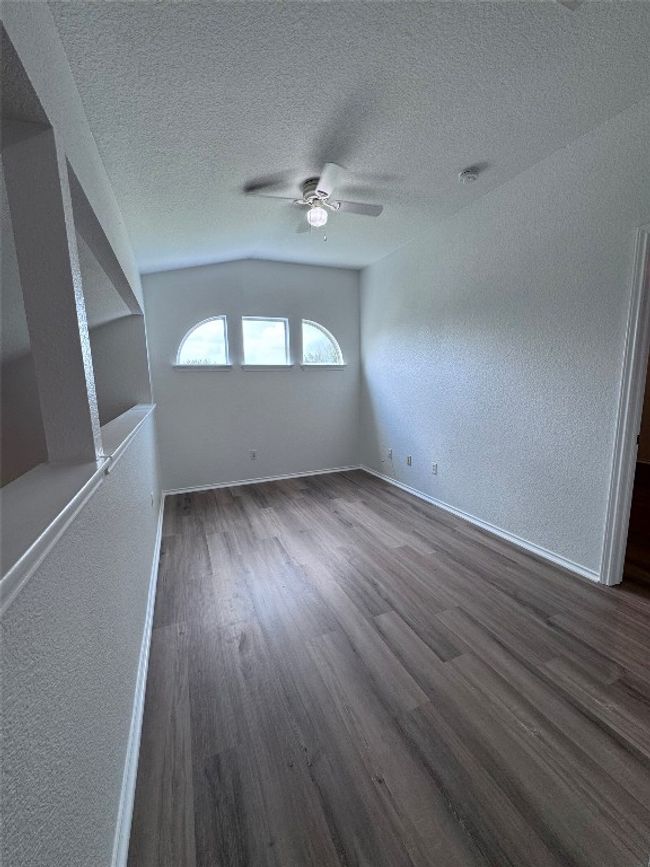 Unfurnished room with dark wood-style flooring, ceiling fan, a textured wall, a textured ceiling, and a smoke detector | Image 22