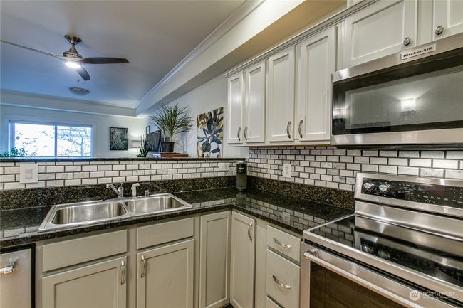 Kitchen features granite counters and subway tile backsplash | Image 7