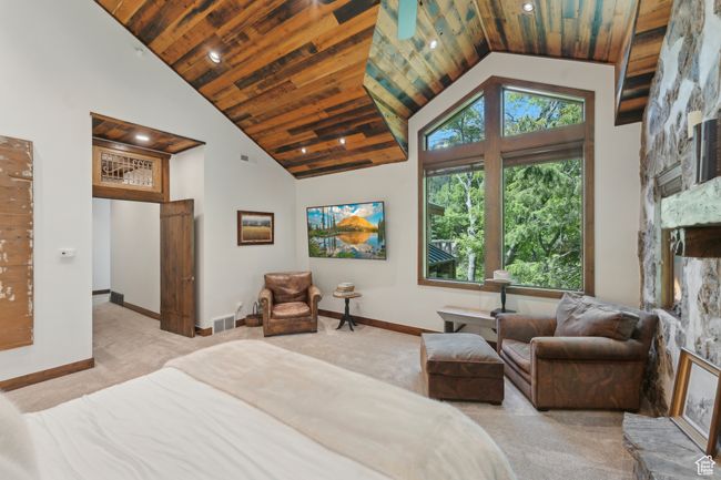 Carpeted bedroom featuring wood ceiling, high vaulted ceiling, a large fireplace, and recessed lighting | Image 18