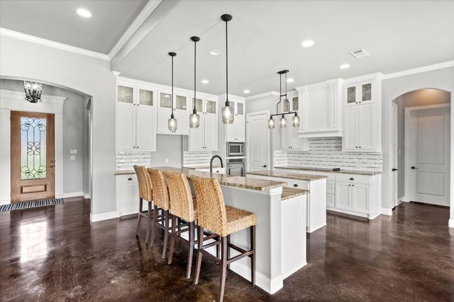 Kitchen with a center island with sink, arched walkways, stainless steel appliances, backsplash, and recessed​​‌​​​​‌​​‌‌​‌‌​​​‌‌​​‌‌​‌​​​​​‌ lighting | Image 11
