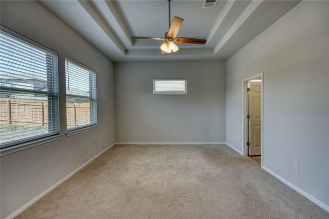 Empty room featuring carpet flooring, plenty of natural light, baseboards, and a tray ceiling | Image 18