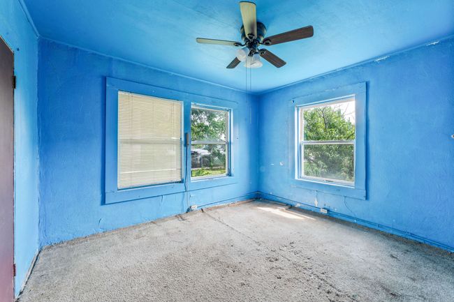 Carpeted empty room with healthy amount of natural light, a ceiling fan, and a textured wall | Image 11