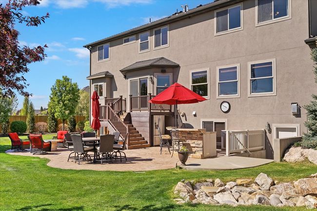 Rear view of house with a lawn, stucco siding, a patio area, and stairway | Image 53