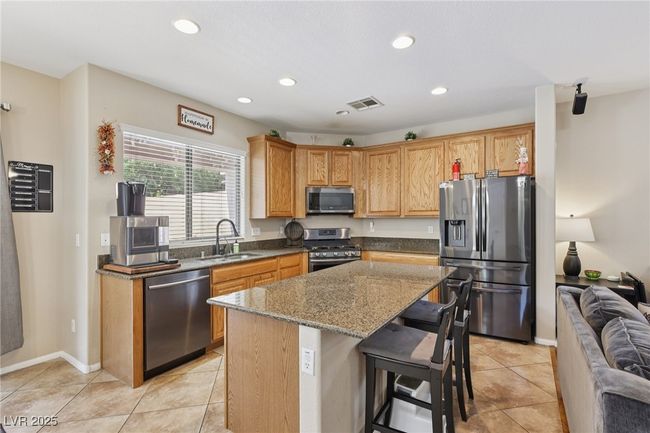 Kitchen with appliances with stainless steel finishes, a sink, stone countertops, a kitchen island, and recessed lighting | Image 28