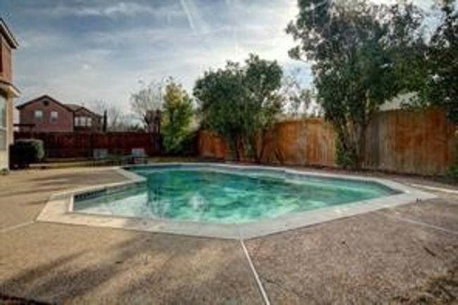 View of swimming pool with a patio area and a fenced backyard | Image 17