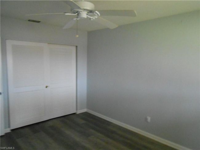 Unfurnished bedroom with baseboards, visible vents, dark wood-style floors, ceiling fan, and a closet | Image 14