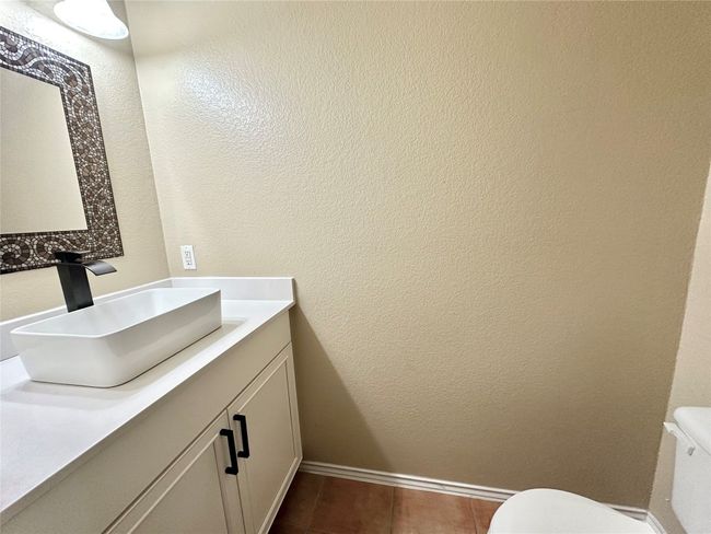 Bathroom with vanity, a textured wall, and tile patterned floors | Image 10