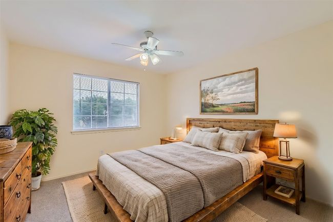 Bedroom with light colored carpet, ceiling fan, and baseboards | Image 17