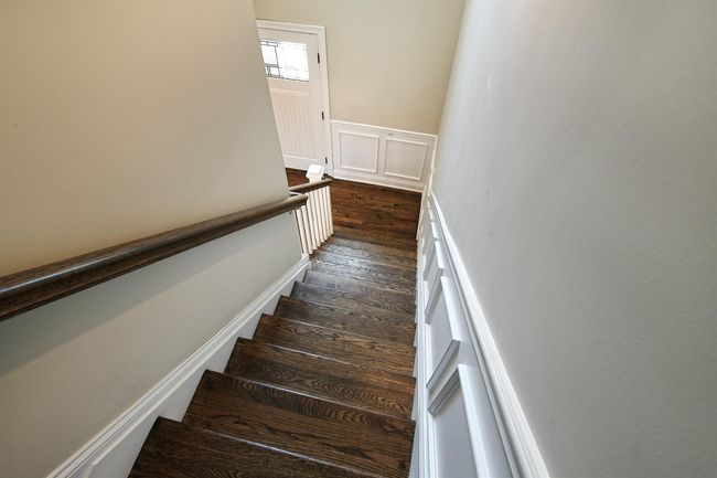 Stairway with a wainscoted wall and wood finished floors | Image 34