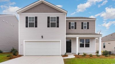 View of front of home featuring a front yard, central AC unit, and a garage | Image 2