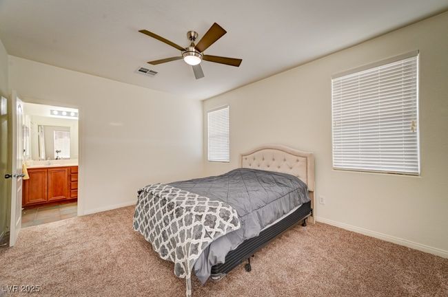 Bedroom featuring light carpet, connected bathroom, and ceiling fan | Image 20