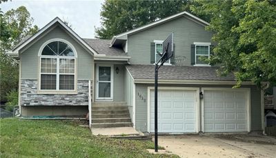 View of front facade with a front yard and a garage | Image 1