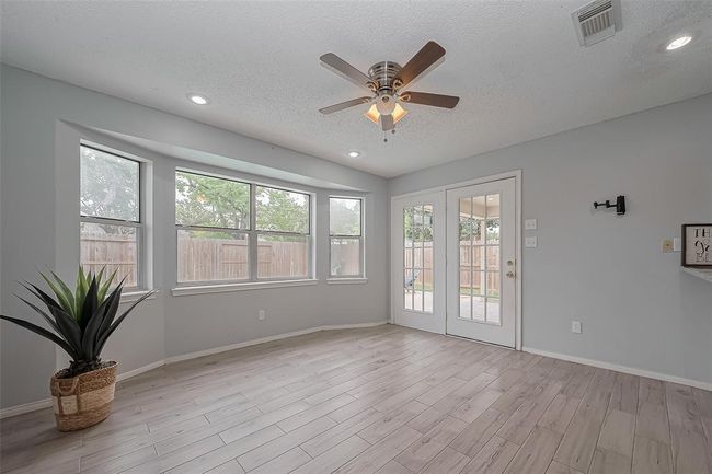 Whether you're preparing meals, entertaining guests, or enjoying quiet evening at home, this bright and inviting space brings everyone together with ease. Natural light pours in through the sunroom, creating a warm and welcoming atmosphere throughout the main living areas. | Image 12