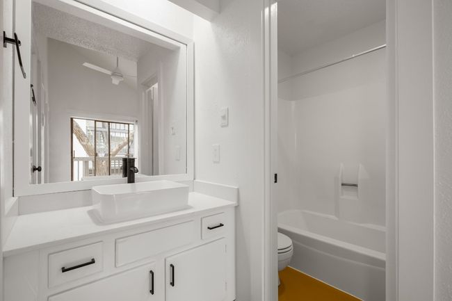 Full bath featuring toilet, vanity, shower / bathing tub combination, and a textured ceiling | Image 13