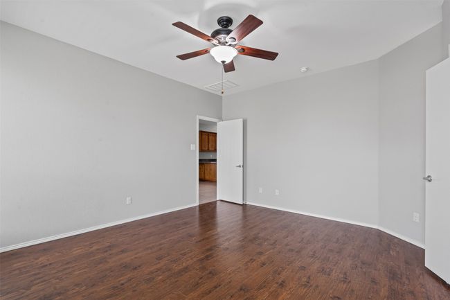 Spare room with wood finished floors, ceiling fan, and a smoke detector | Image 12