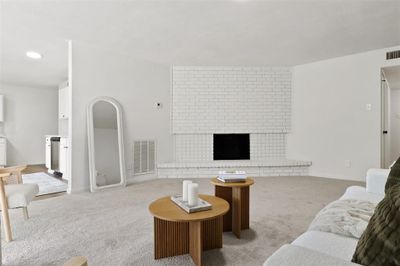 Carpeted living room with a fireplace | Image 2