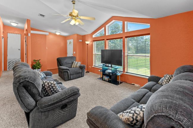 Living room with vaulted ceiling, healthy amount of natural light, ceiling fan | Image 7