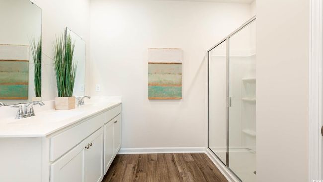 Bathroom with a sink, double vanity, a shower stall, and wood finished floors | Image 14