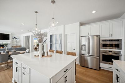 (Photo of model home, finishes will vary) Enjoy plenty of seating at the kitchen island and dining area adjacent to the kitchen. Perfect for entertaining or having a family meal together. | Image 3