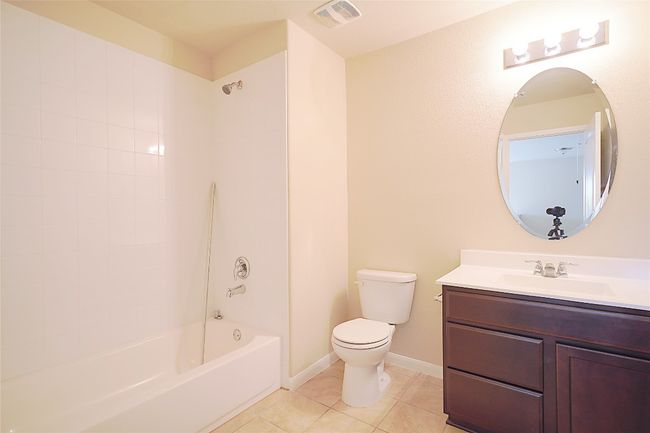 Full bath with vanity, tile patterned flooring, and shower / tub combination | Image 15