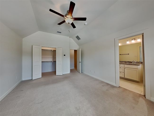 Unfurnished bedroom with vaulted ceiling, light colored carpet, a sink, and baseboards | Image 5