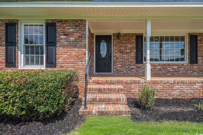 Property entrance featuring a covered porch and an elegant LED dusk to dawn porch light. | Image 4