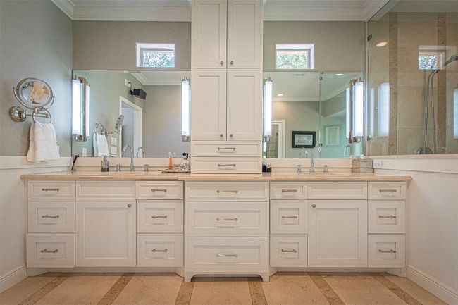 Bathroom with a tile shower, crown molding, baseboards, double vanity, and inlaid floor details | Image 19