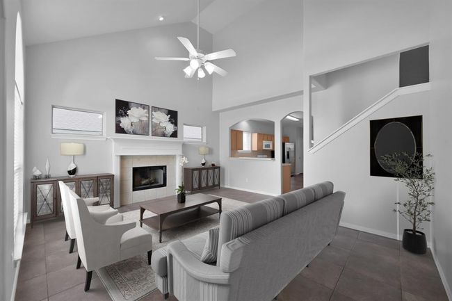 This bright and airy living room is the heart of the home. Featuring a high ceiling, wood burning fireplace that's also plumbed for gas, and decorated surround & mantel, and an oversized arched window, you'll enjoy entertaining and relaxing in this warm and inviting space.*Virtually staged | Image 5