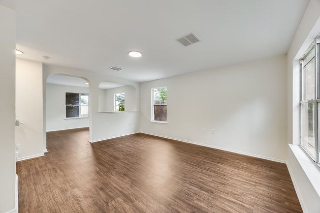 Empty room with dark wood-style floors, arched walkways, and baseboards | Image 6