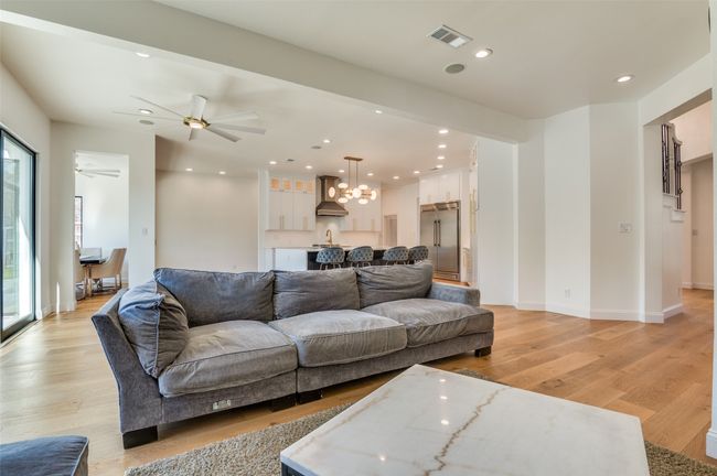 Living area featuring visible vents, ceiling fan with notable chandelier, light wood finished floors, and recessed lighting | Image 20