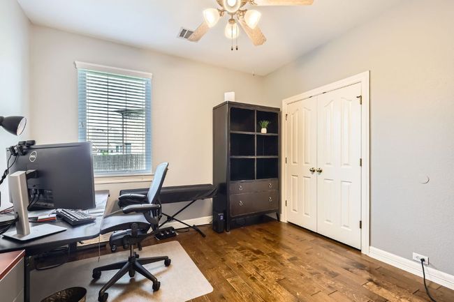 First floor bedroom used as office space featuring a ceiling fan, hardwood floor | Image 11