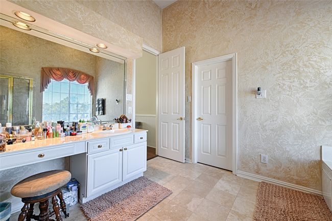 Bathroom with baseboards, a shower stall, vanity, and wallpapered walls | Image 35