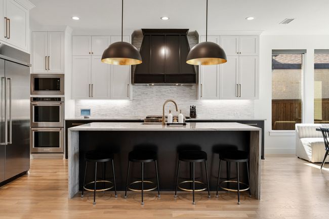 Kitchen featuring built in appliances, custom range hood, a sink, light wood-type flooring, and a kitchen breakfast bar | Image 10