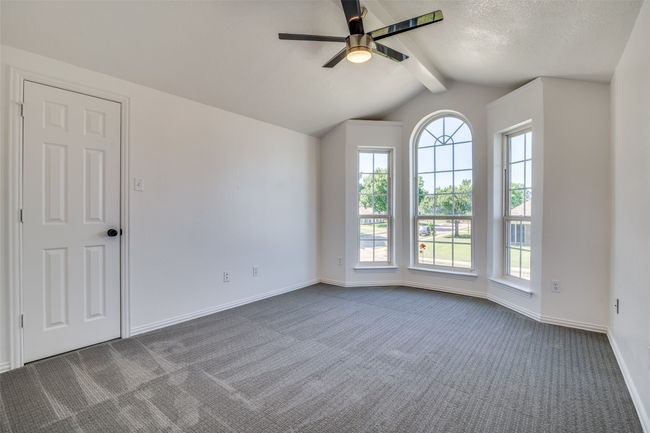 Spare room with ceiling fan, dark colored carpet, baseboards, and a textured ceiling | Image 22