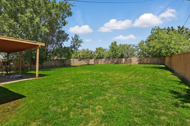 View of yard featuring a fenced backyard and a patio | Image 31
