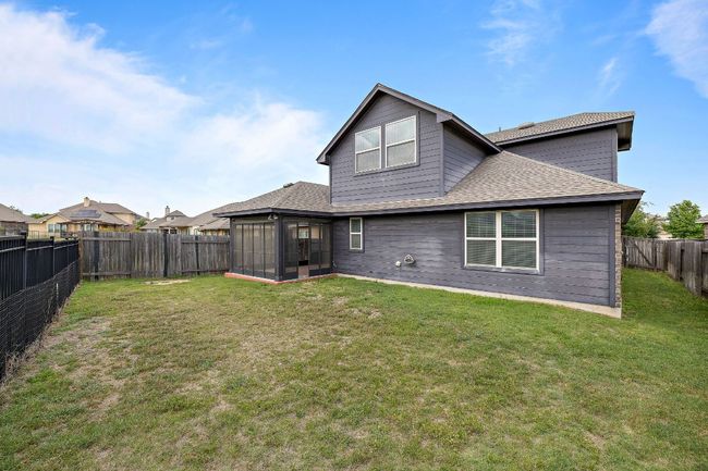 Back of property with a sunroom, a fenced backyard, roof with shingles, and a lawn | Image 31