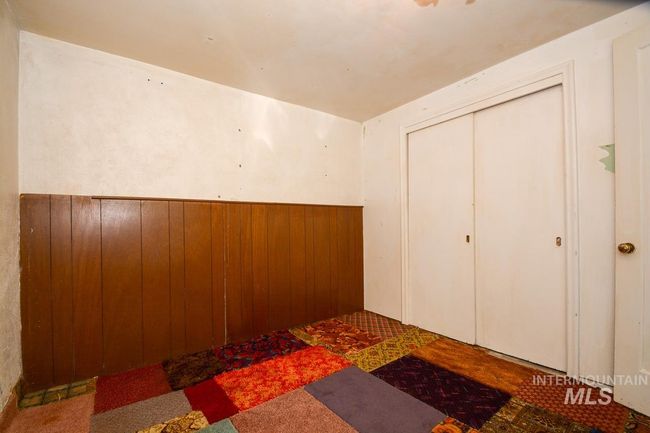 Unfurnished bedroom with a closet and wood walls | Image 31