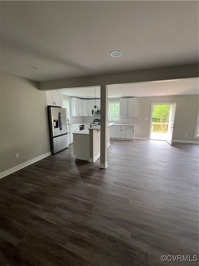 Kitchen with open floor plan, white cabinets, refrigerator, and tasteful backsplash | Image 25